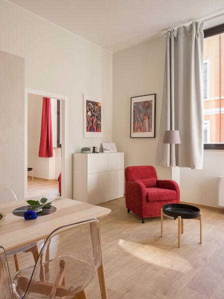 A modern living room with kitchen area, featuring a table, sofa, chairs, coffee table, and window with curtains, and eclectic decor ending the sentence.